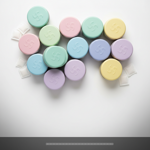 Pastel nicotine pouch containers in mint, pink, blue, yellow and purple clustered together on a white background