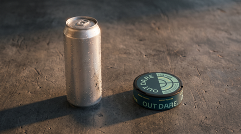 Small round energy pouch can placed beside a tall energy drink can on a dark concrete worktop