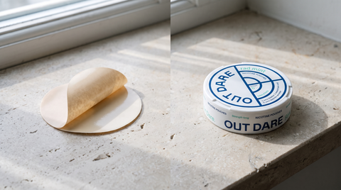 Beige nicotine patch with peel-back liner beside a nicotine pouch can on a pale stone windowsill