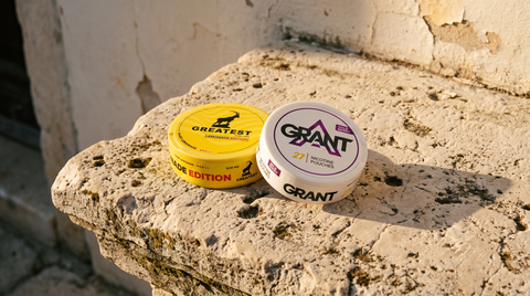 Two nicotine pouch cans on a sun-warmed limestone table in a Balkan old-town setting