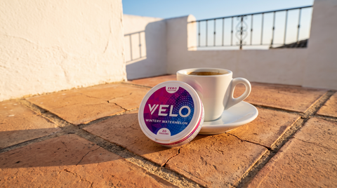 Nicotine pouch can on a terracotta terrace beside a small espresso cup in Spain