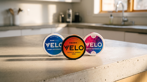 Three VELO nicotine pouch cans in a row on a kitchen counter showing different VELO pouches flavours