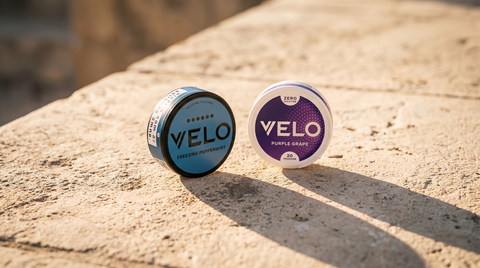 Two VELO snus nicotine pouch cans on bleached limestone in strong Mediterranean afternoon light