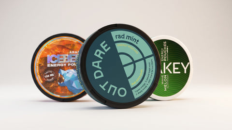 OutDare Energy pouches in front, ICEBERG and WAKEY energy pouches behind — caffeine, zero nicotine